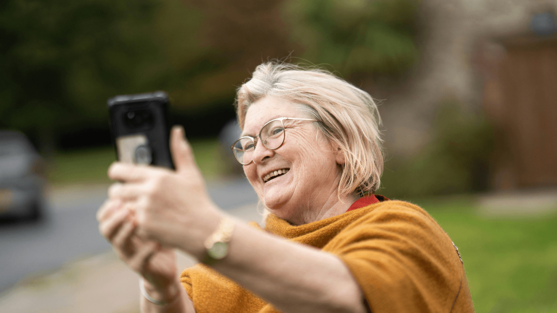 An older woman takes a selfie with a mobile phone
