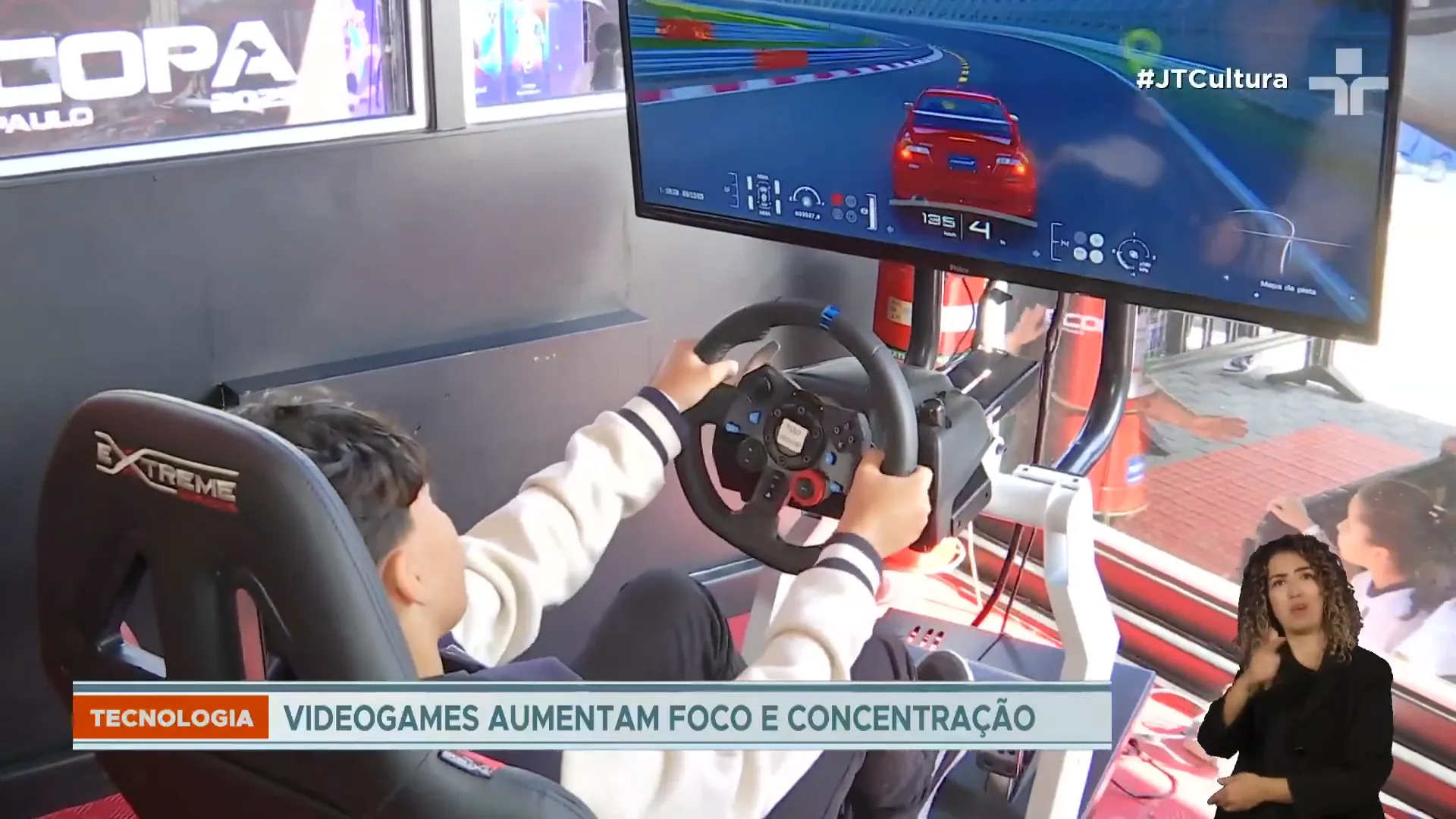 Menino joga em simulador de corrida com volante, em reportagem da TV Cultura sobre videogames e concentração