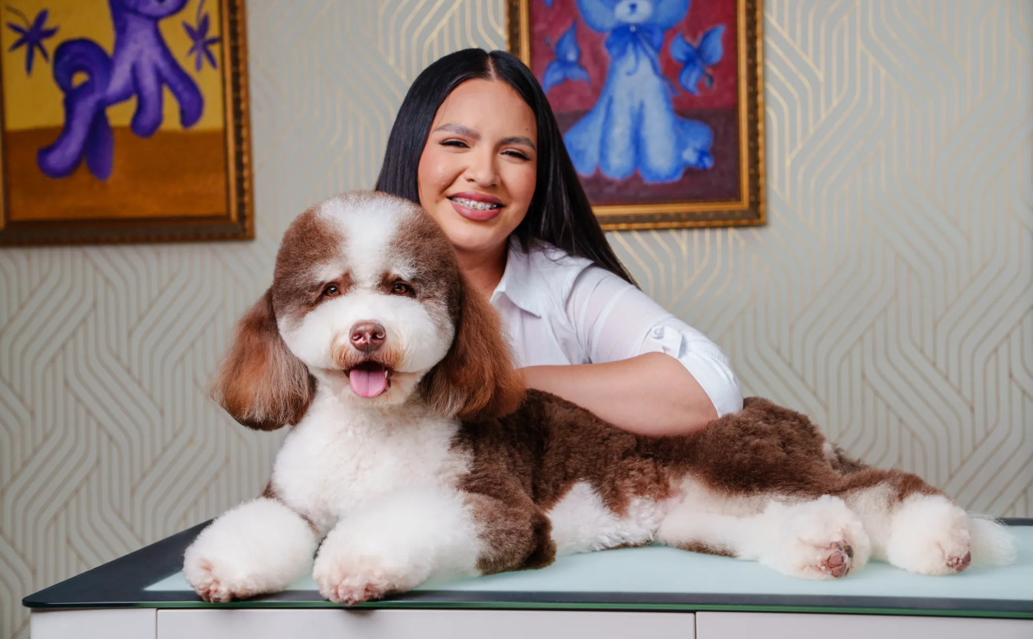 Smiling groomer beside a brown-and-white dog at MIMO University Heights.