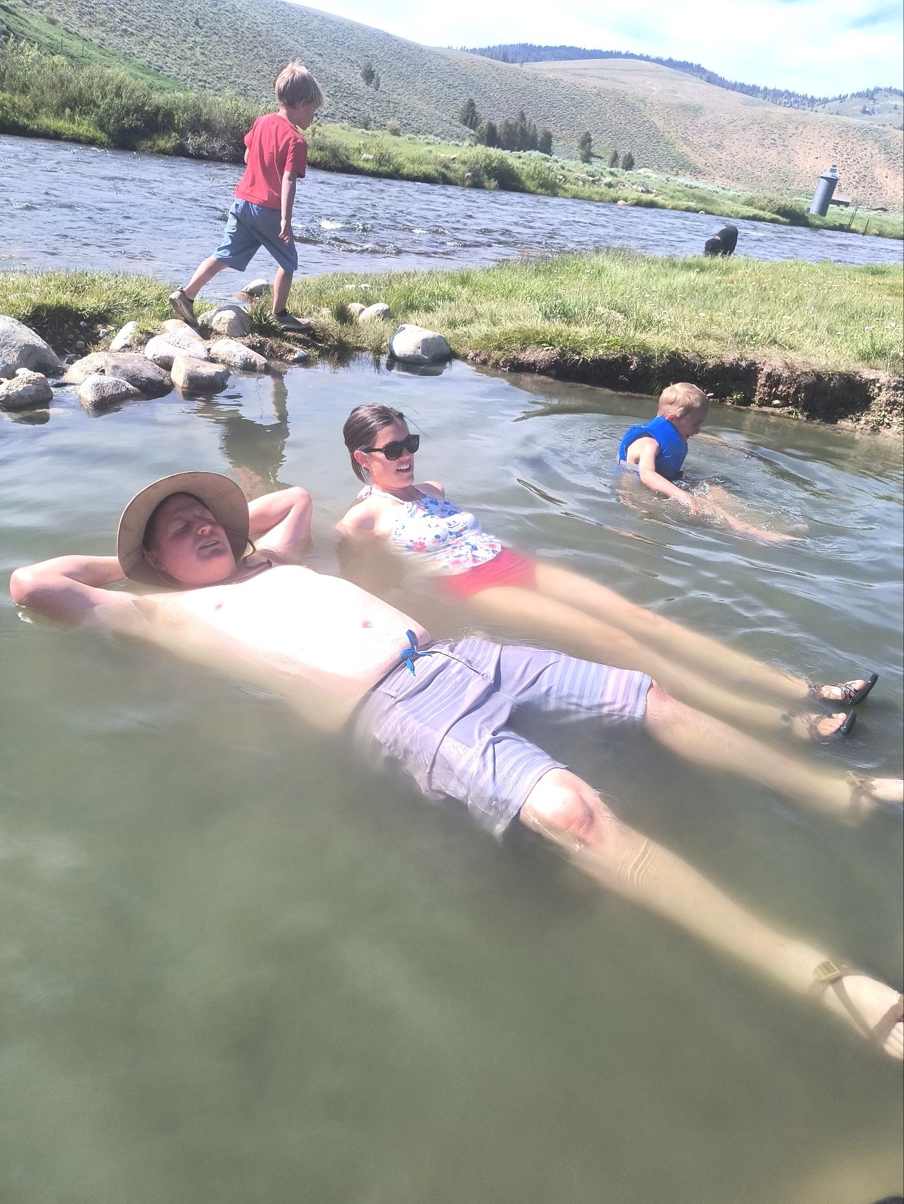 Family soaking in the rock-lined pools of Sunbeam Hot Springs along the Salmon River