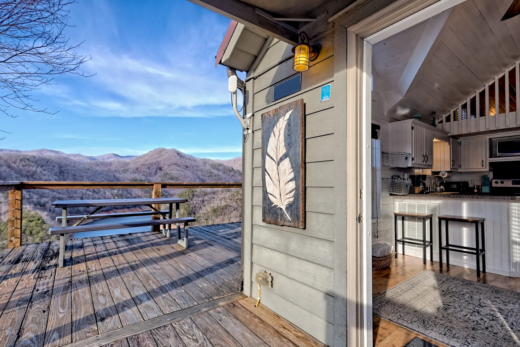 Tiny Tuck deck with a picnic table and mountain view, next to the open kitchen door