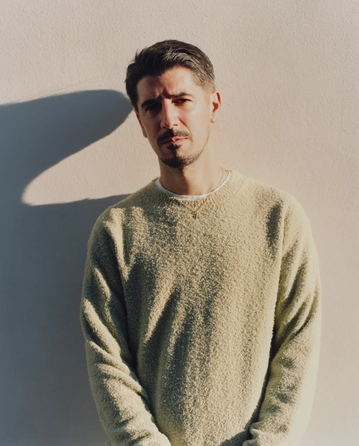 A fluffy gray rabbit rests on a floral chair.