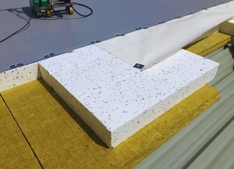 Détail des matériaux d’isolation thermique pour bardage : laine de roche, tôle, et mousse.