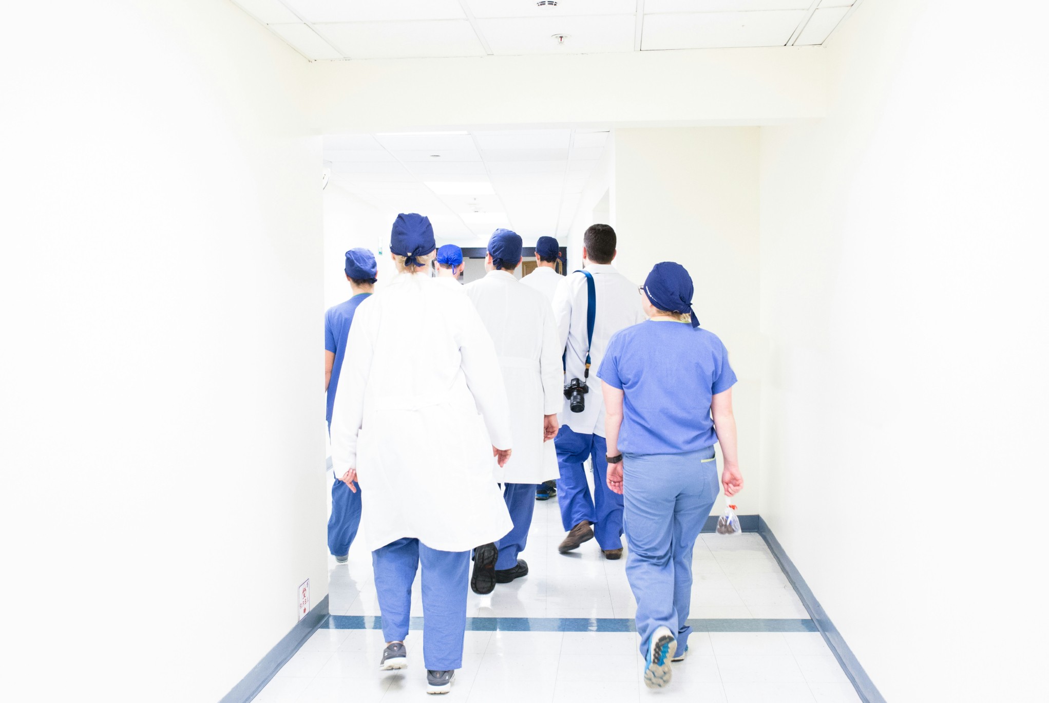 Group of healthcare professionals walking down a hospital hallway, representing financial challenges in healthcare such as staffing costs and resource allocation.