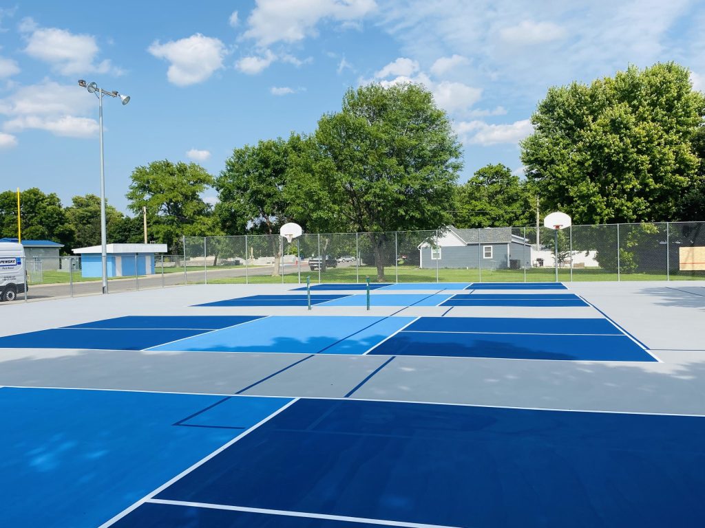 Transformed pickleball courts in Imperial City, NE, featuring a newly resurfaced acrylic surface with four dedicated pickleball courts and ghost lines for tennis.