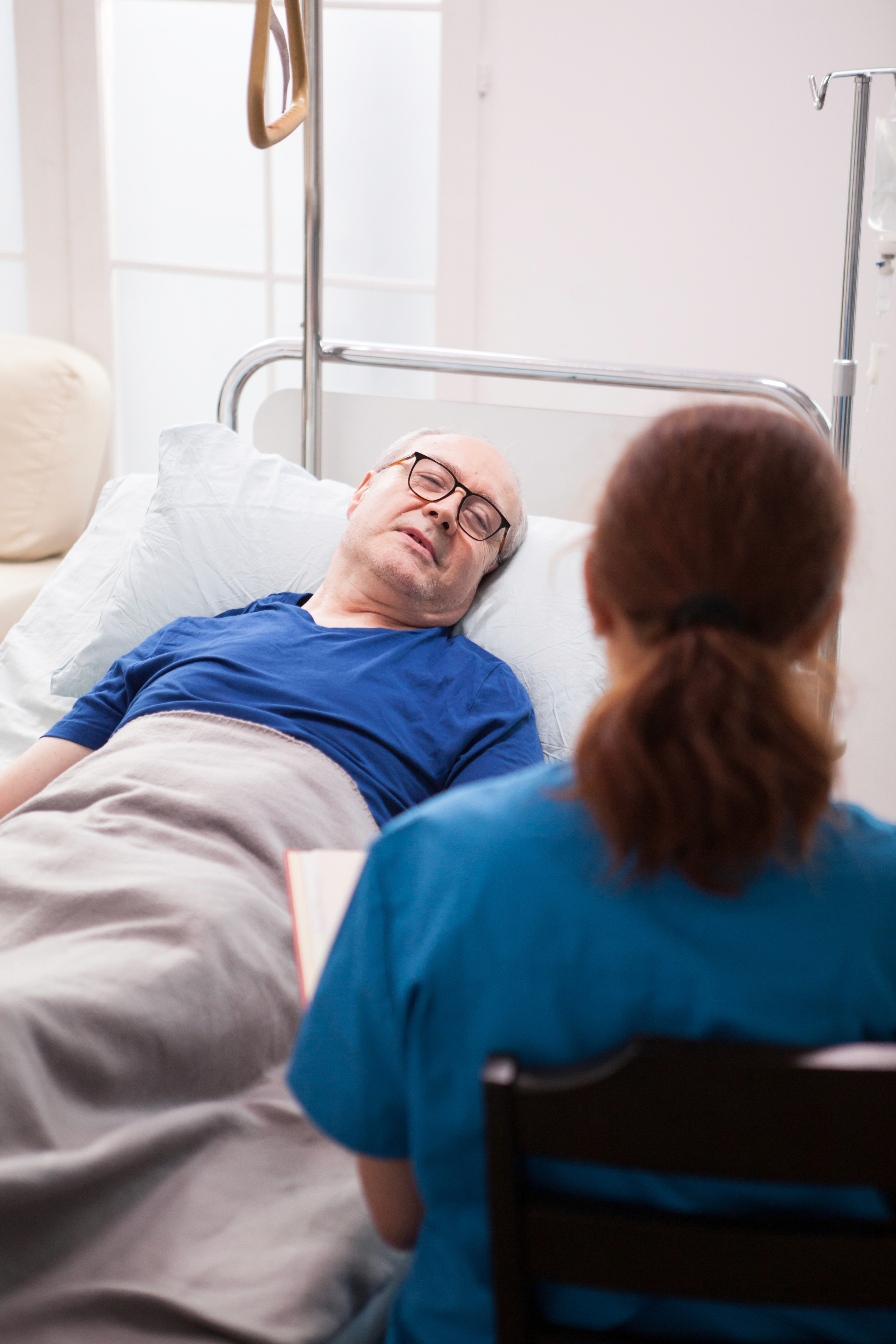 backview of nurse sitting and talking to an elder