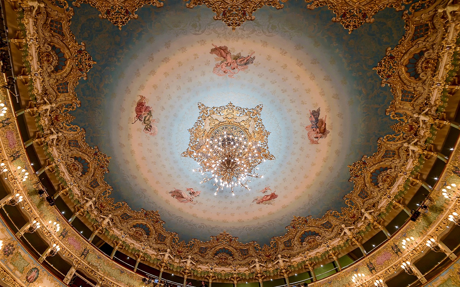 Lobi dan salon Teatro La Fenice, interior gedung opera Venesia dengan lampu gantung yang megah dan dekorasi elegan.