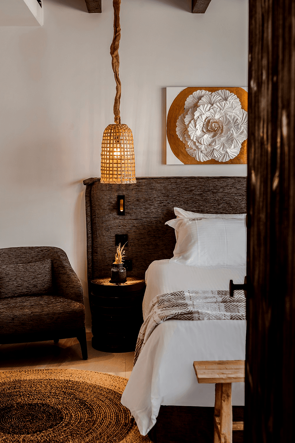 High-contrast Moroccan Mediterranean junior suite in Ayia Napa with organic white-wash walls and bespoke timber headboard by topos design studio