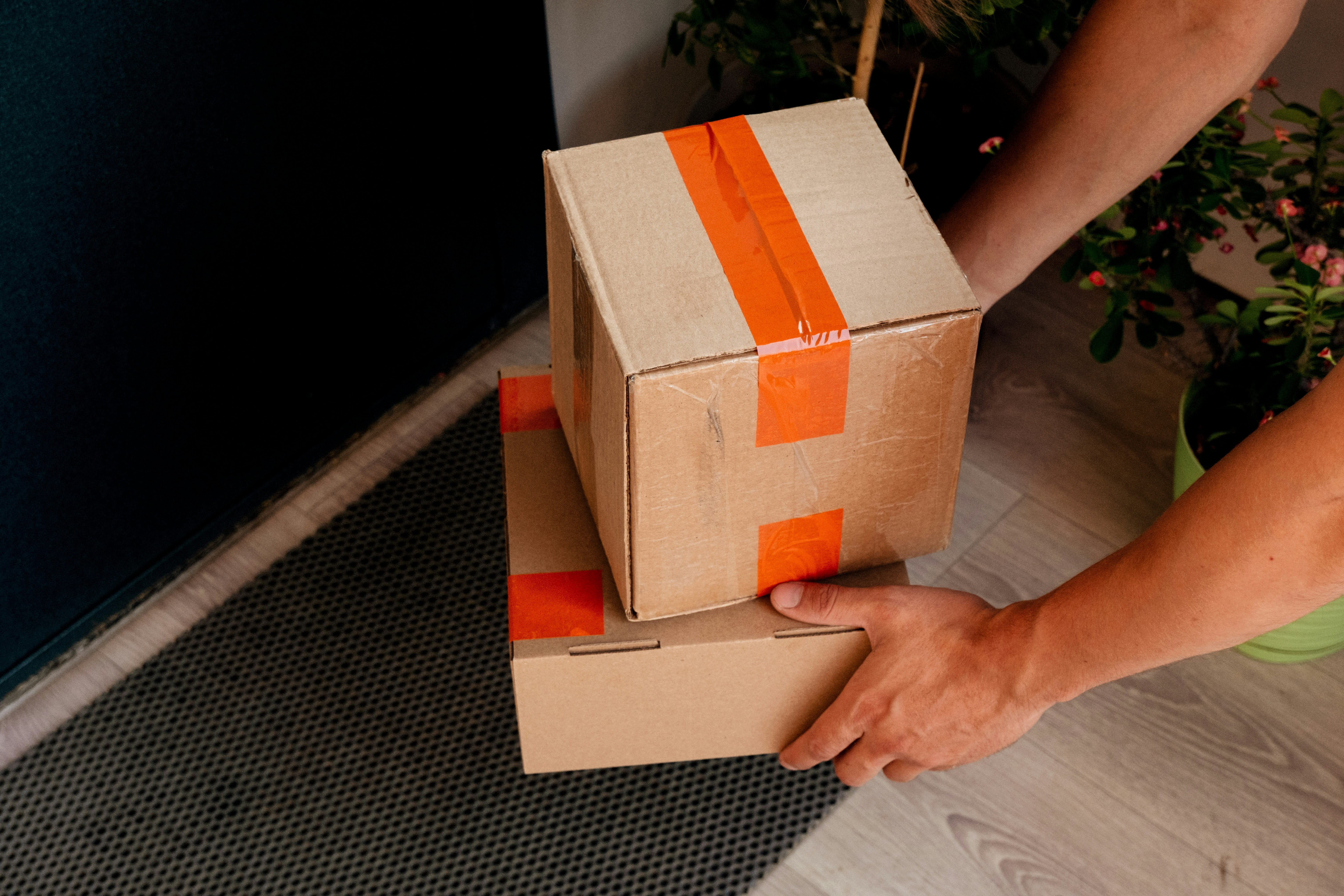 An individual carrying two parcels for dispatch or delivery.