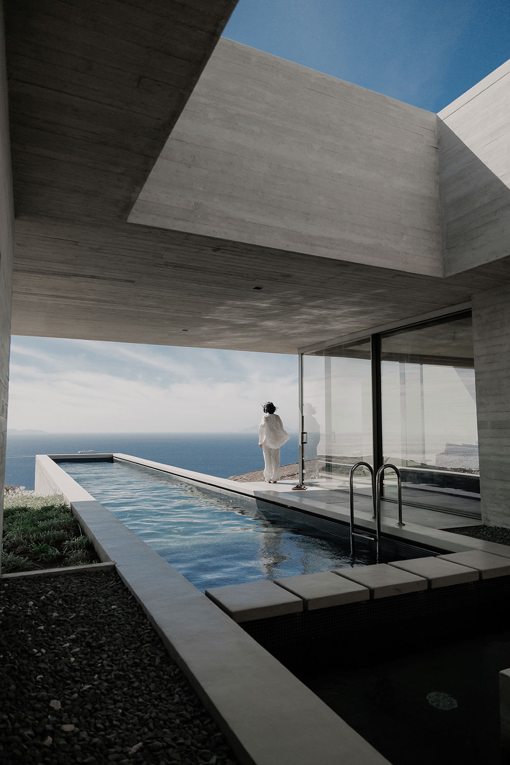 Lap pool on a cliff edge with a figure at the glass