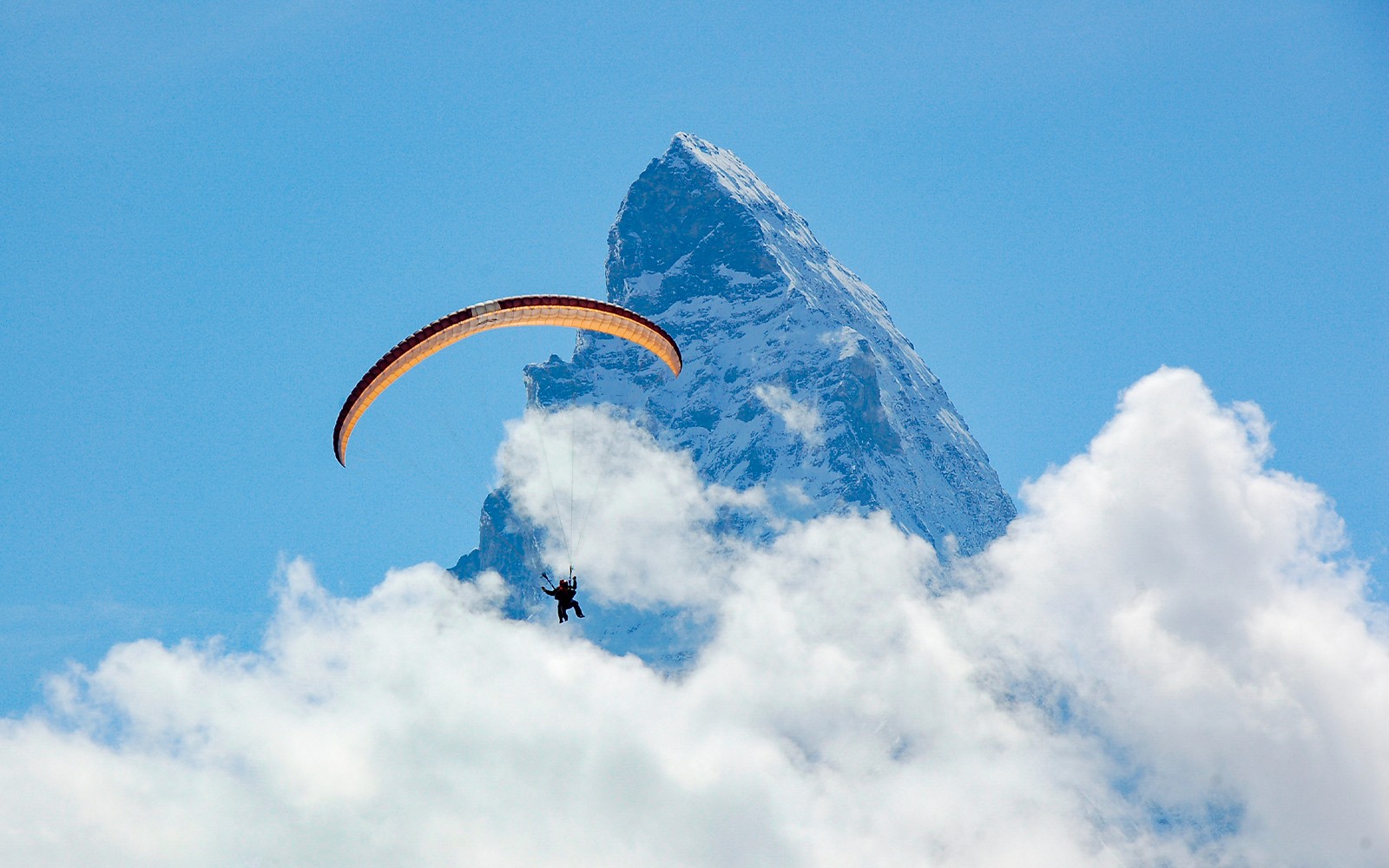 स्विट्ज़रलैंड के ज़र्मट में मेटरहॉर्न के पास पैराग्लाइडर उड़ते हुए।