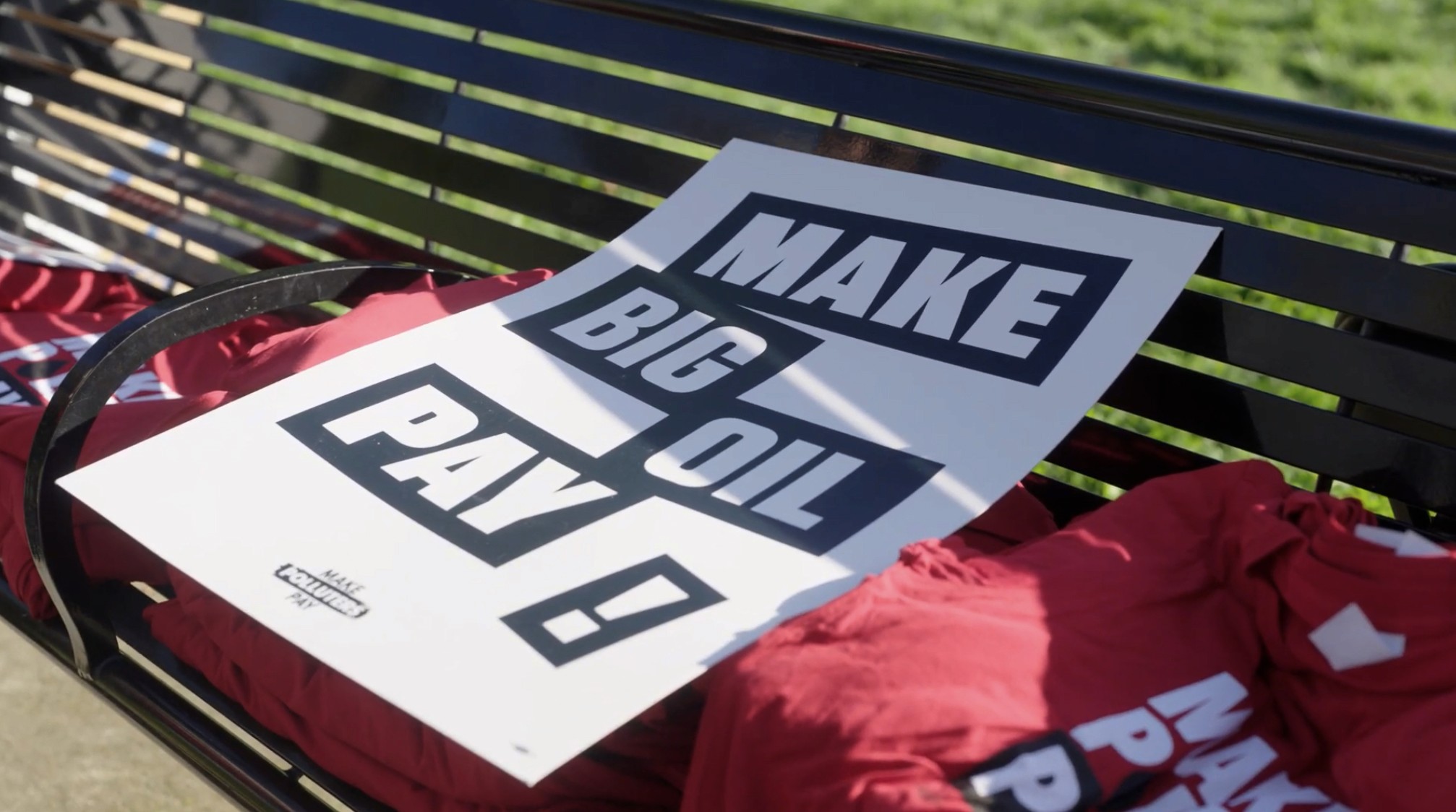 A rally sign that reads "Make Big Oil Pay."