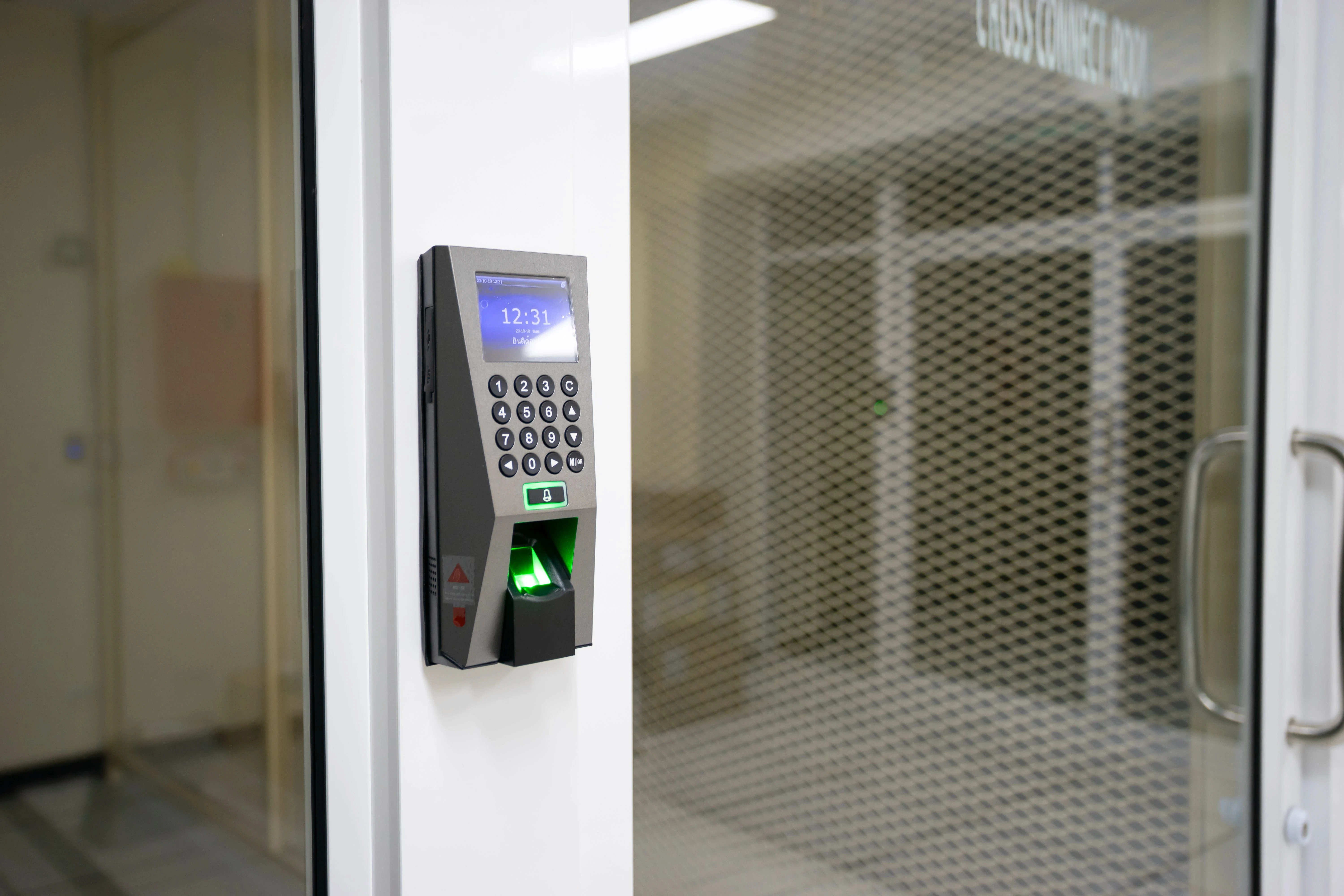 Digital keypad and biometric fingerprint scanner mounted on a white door frame for secure access control.