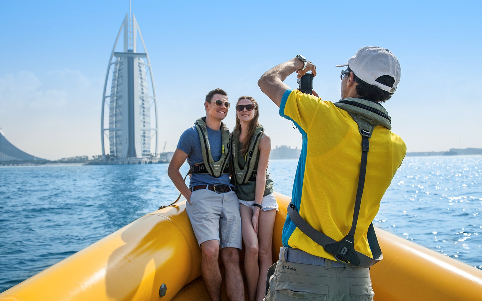 Couple on a speedboat tour in Dubai with Burj Al Arab in the background.