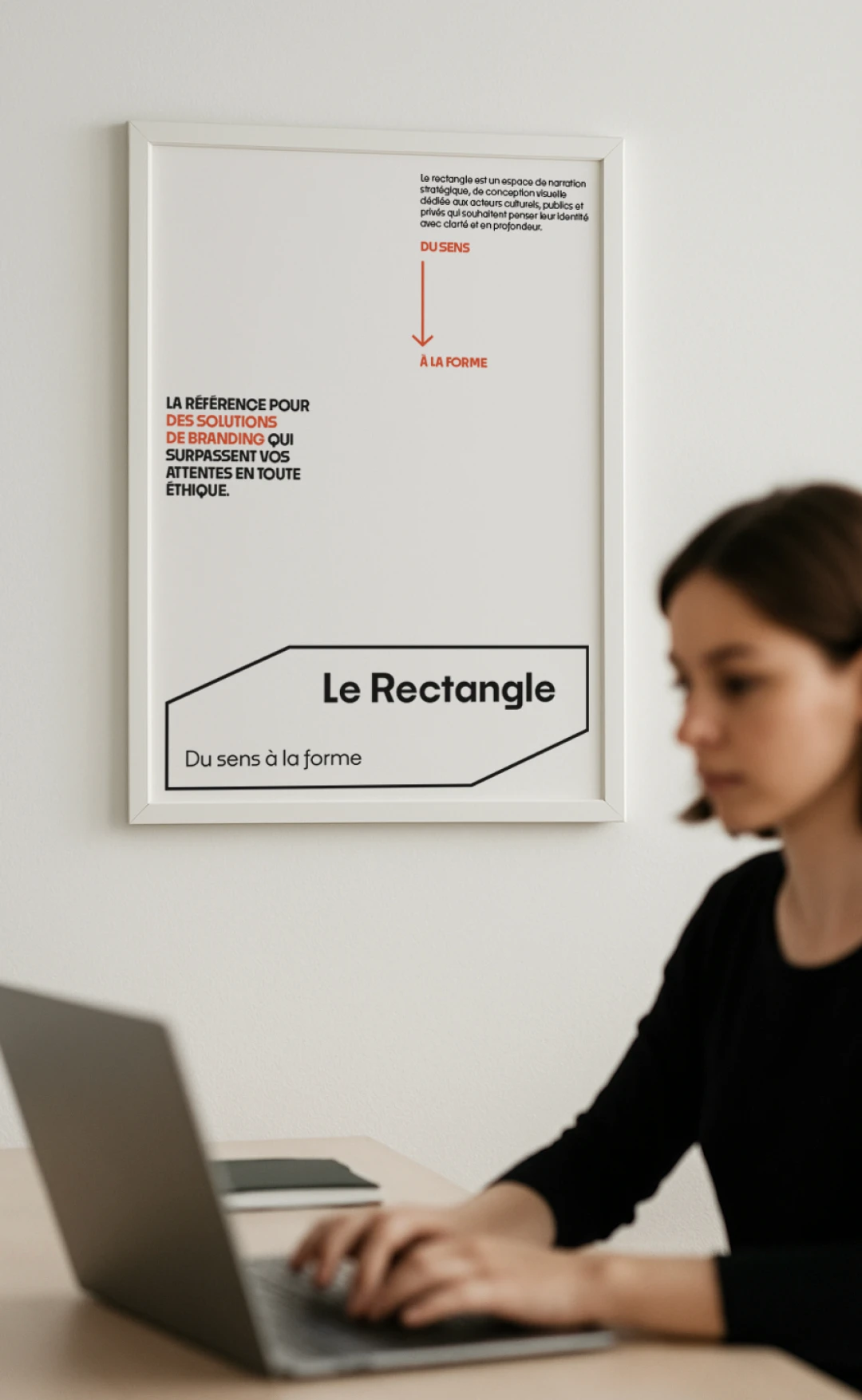 Mockup affiche manifeste version allégée Le Rectangle encadrée en contexte studio — logo outline, baseline "Du sens à la forme" et flèche orange, identité visuelle créée par Tartelette Concept