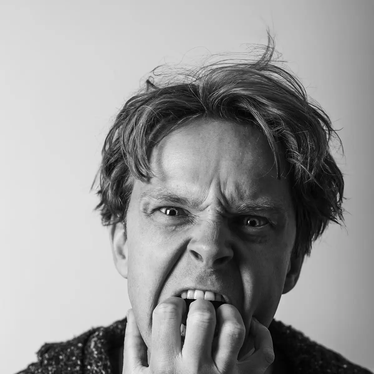 Close-up black and white portrait showing visible frustration, representing user anxiety caused by poor digital experiences.