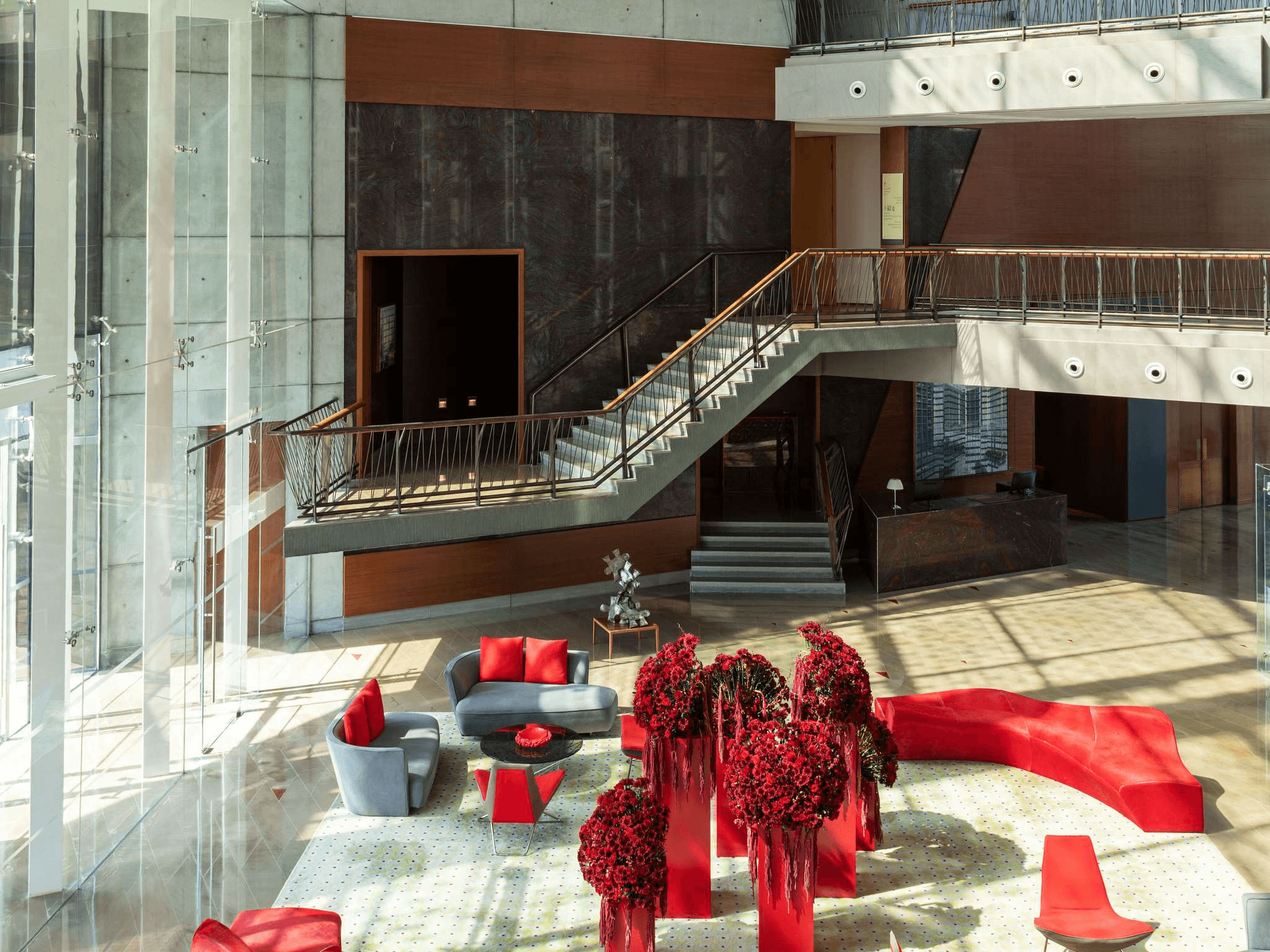 Lobby of Jumeirah Creekside, a pet-friendly hotel with bright red floral décor and modern seating areas.