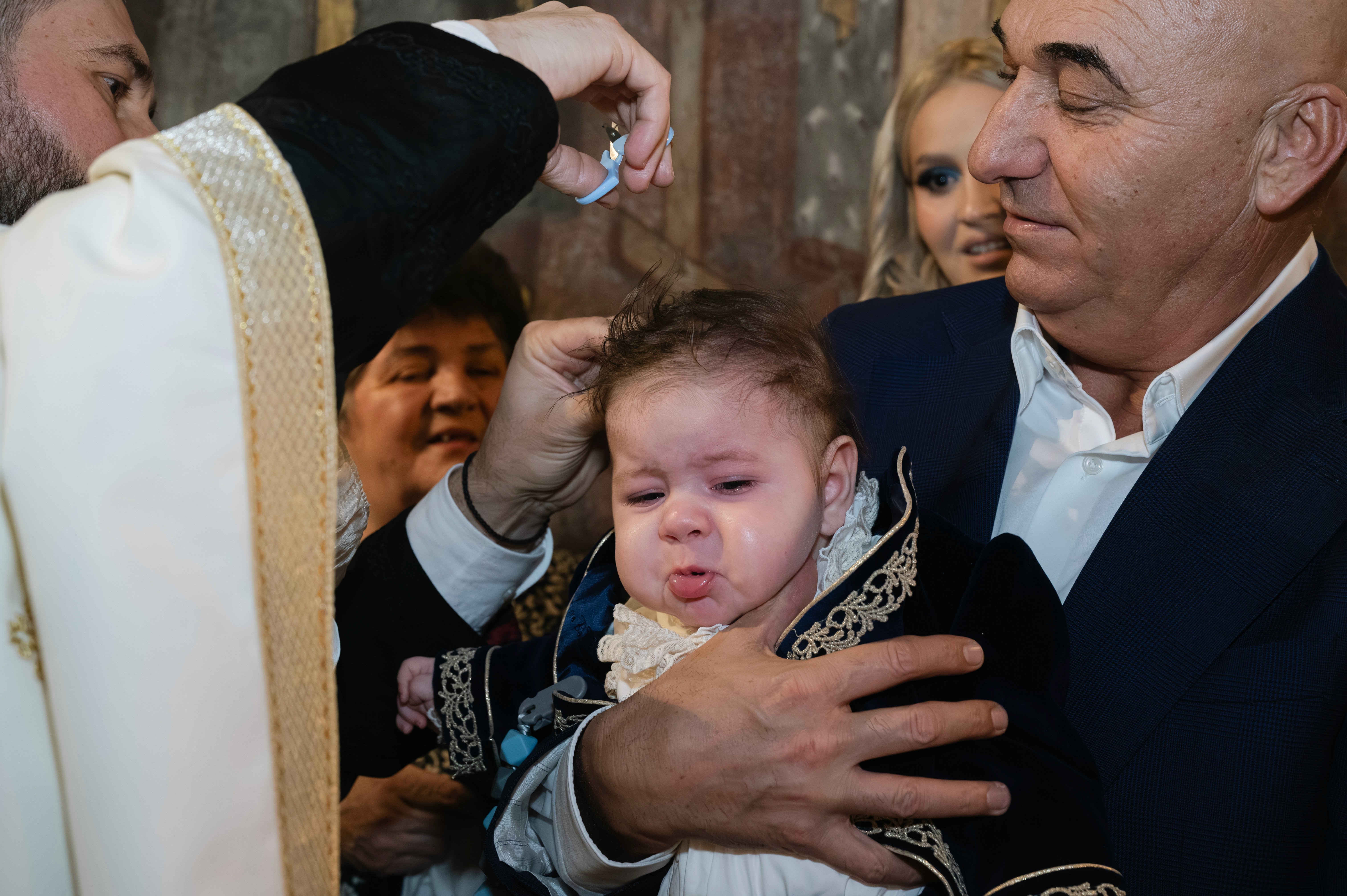 Nasul ținând copilul după ceremonia religioasă, cadru emoțional.