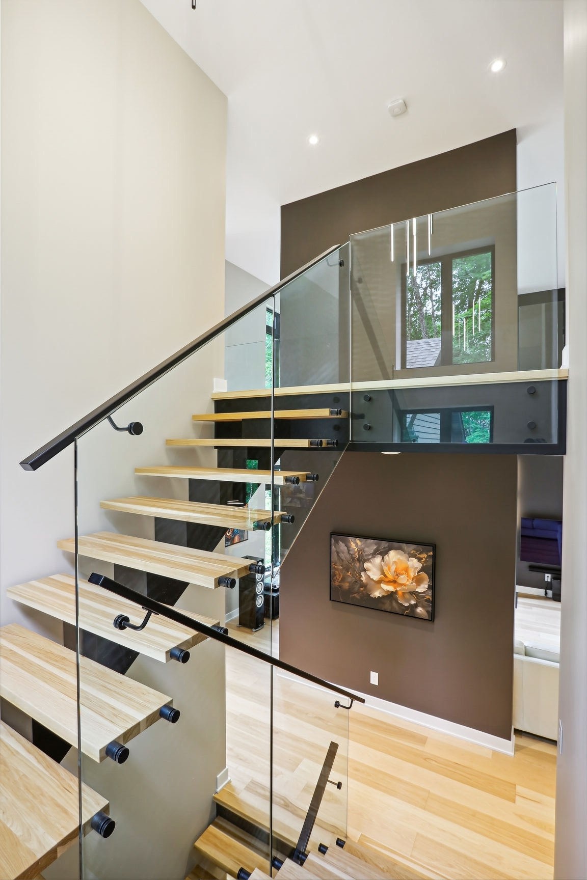 Aire d'escalier avec garde-corps en verre.