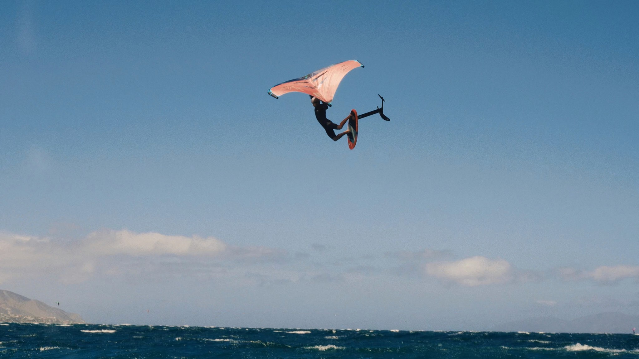 wing foiler doing a big jump