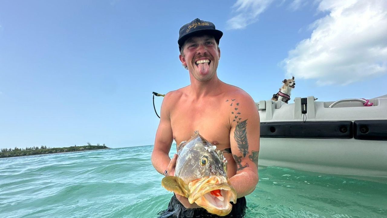 Alfred from Sailing the Pasha wearing a SeaPeople hat and holding a freshly caught fish