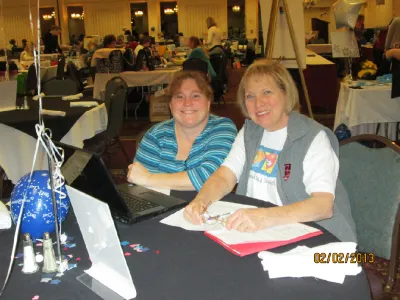 Two women working side by side at a crop table