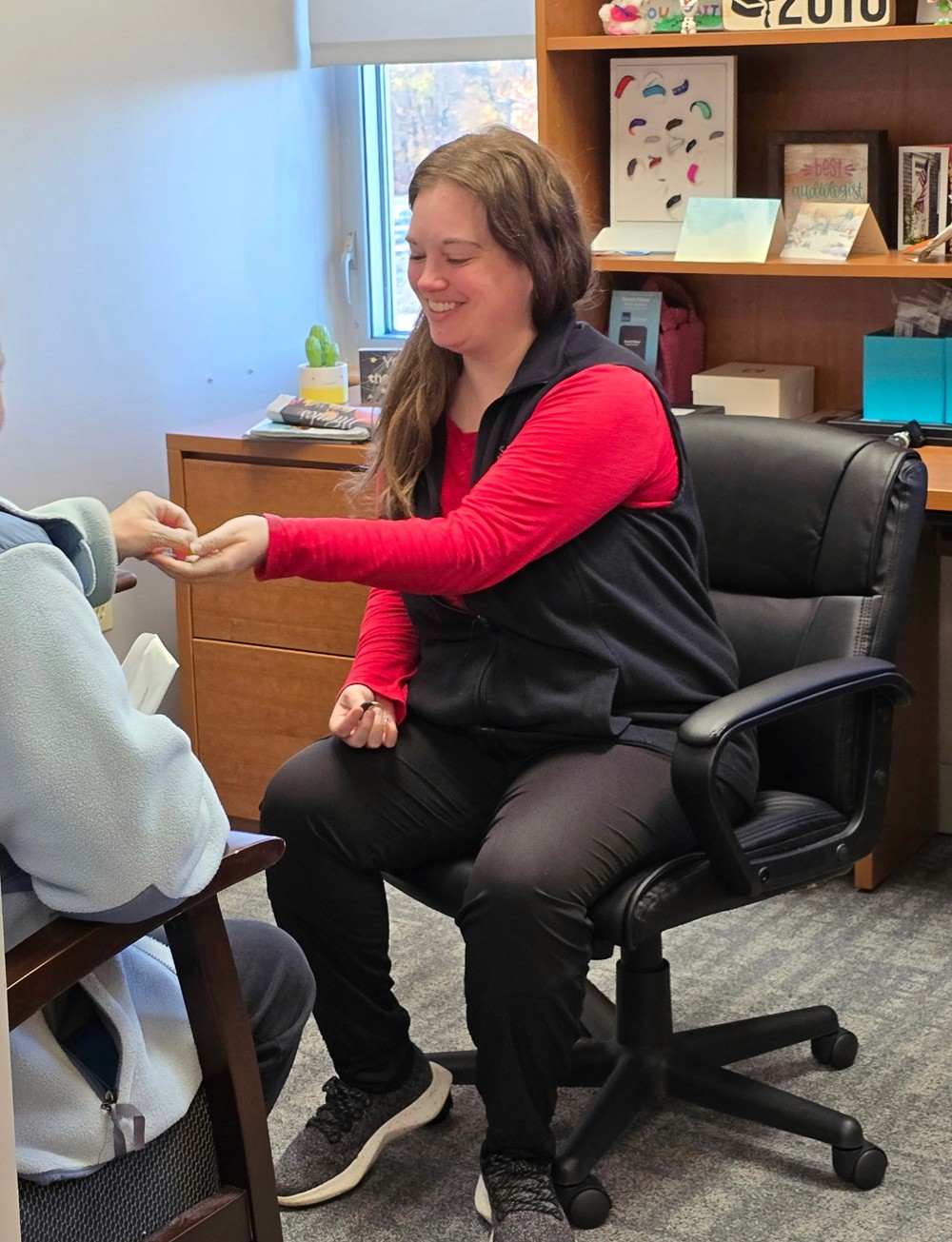 Holding a Hearing aid device shouth shore hearing