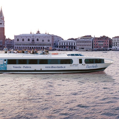 Een boot met het opschrift "Venezia - Padova" vaart over het water, met op de achtergrond historische Venetiaanse gebouwen.