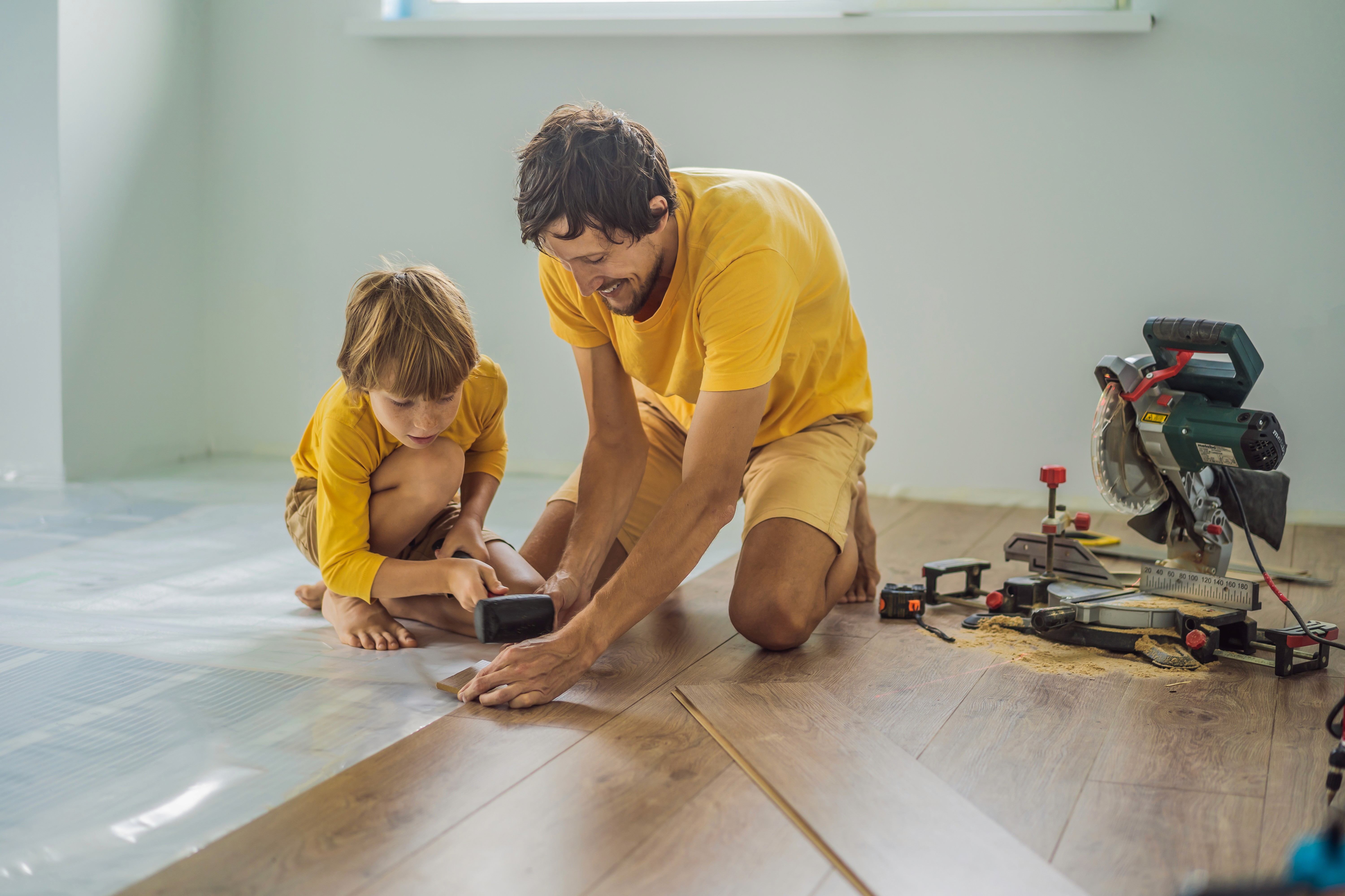 Father and child installing hybrid flooring at home, showing a durable, family-friendly floor built for everyday Australian living.