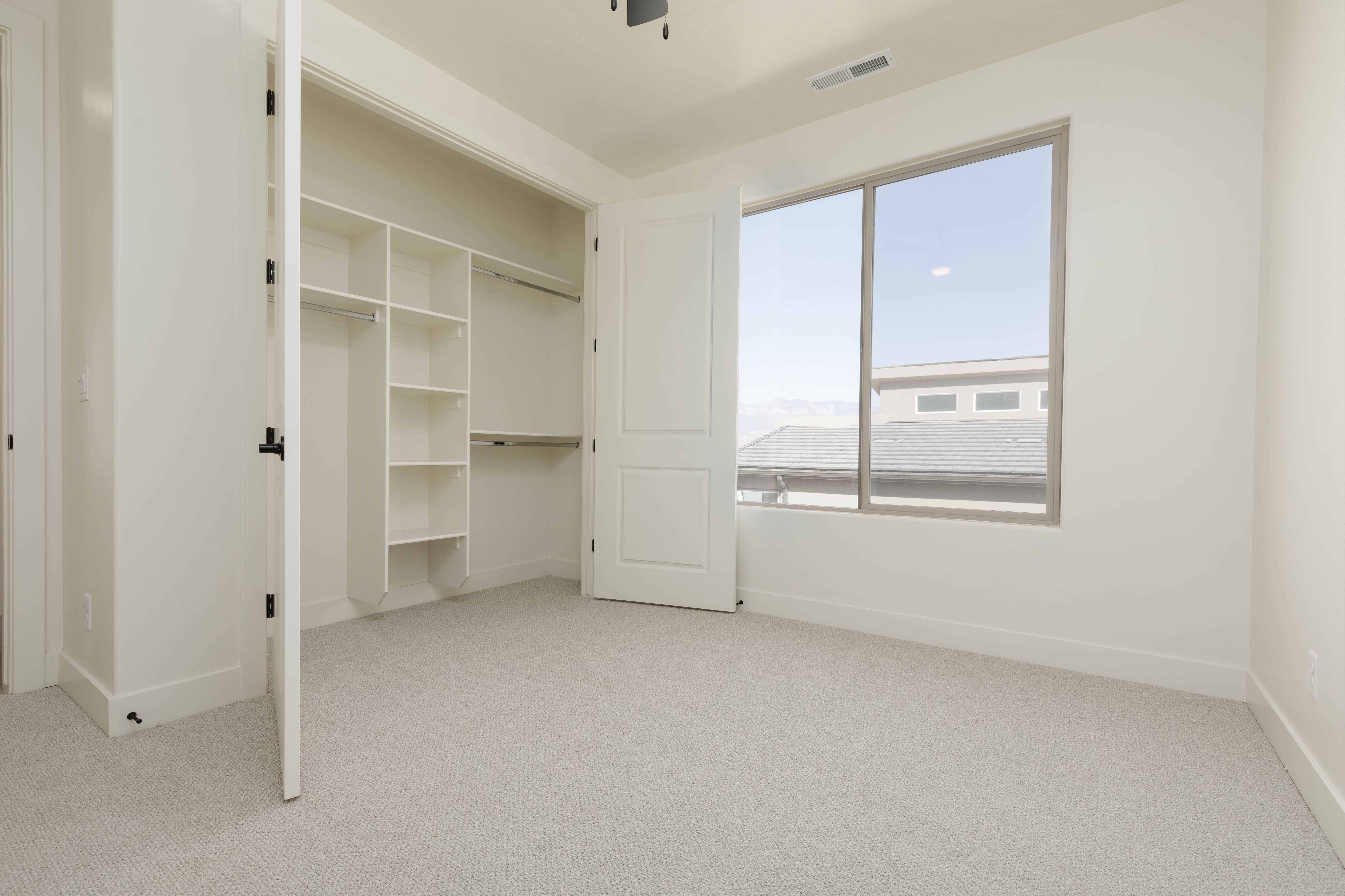 Secondary bedroom with built-in closet and natural light in The Meridian home in Hurricane Utah.