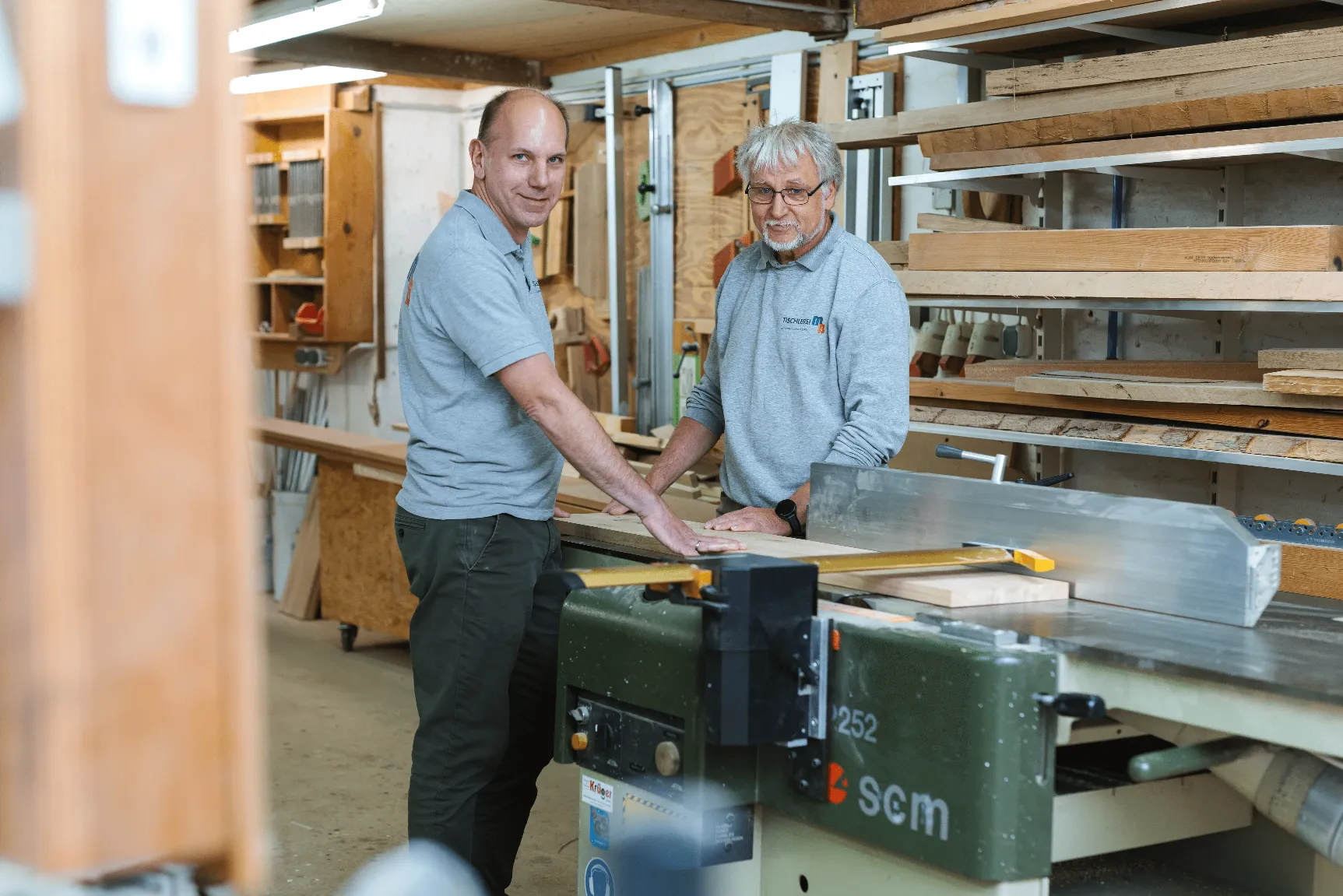 the two founder of raumkreativ sitting on a table and smiling.