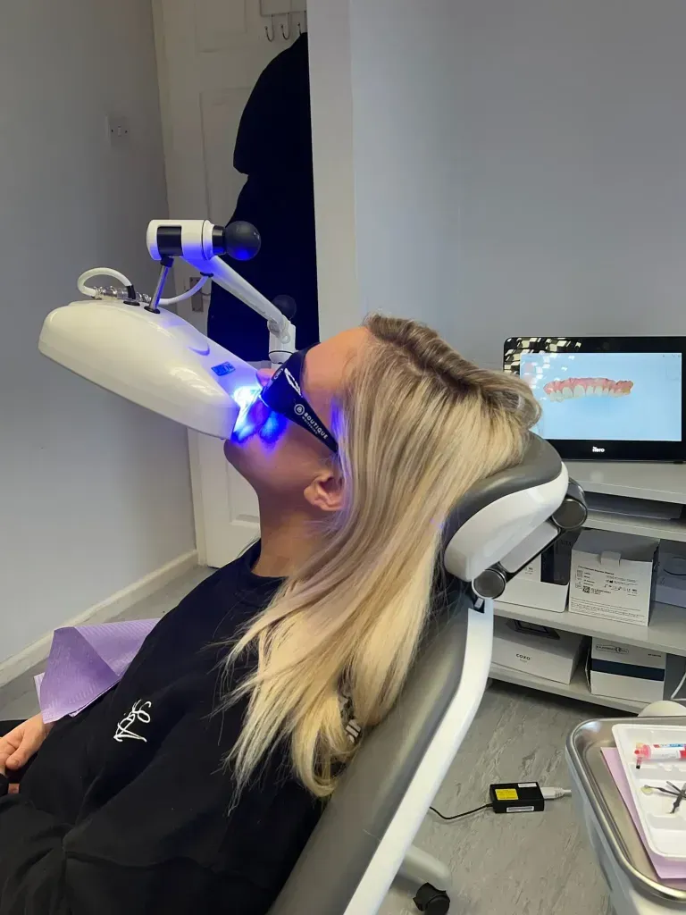A patient is getting her whitening treatment done in the practice.