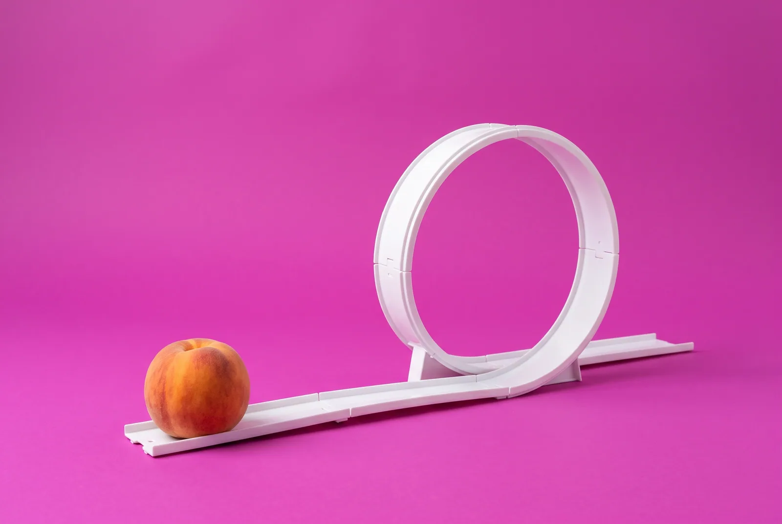 A peach at the start of a looping toy race track, breaking the trigger and urge loop in QUITTR vs Canopy