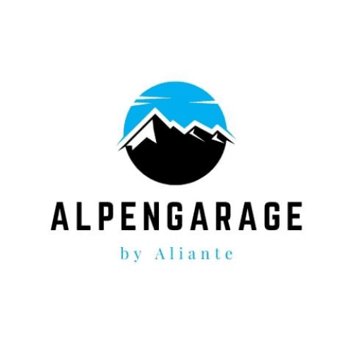 Two people in a workshop, one standing and smiling while the other leans over a car, working on it.