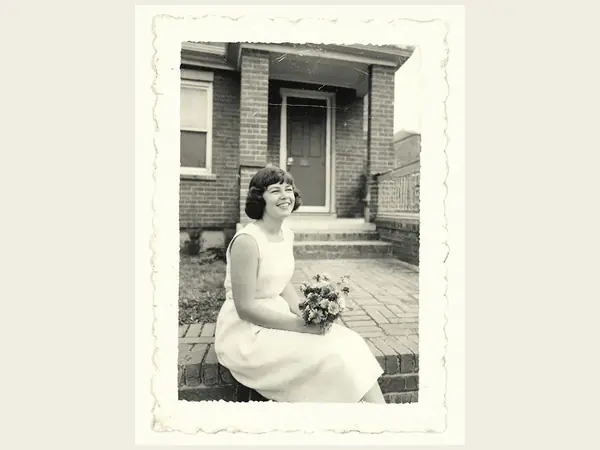My mother at twenty, on the front steps with garden flowers