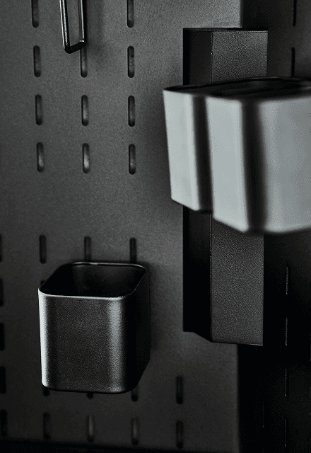 Detailaufnahme der SCOPE Lochrasterwand mit modularen schwarzen Metall-Accessoires, ideal für flexible Organisation und Workspace-Konfigurationen.