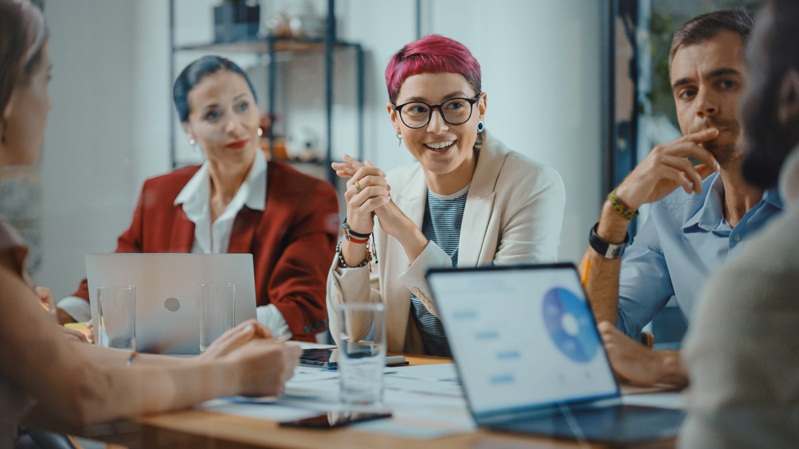 A leadership team in a meeting, discussing a hiring plan