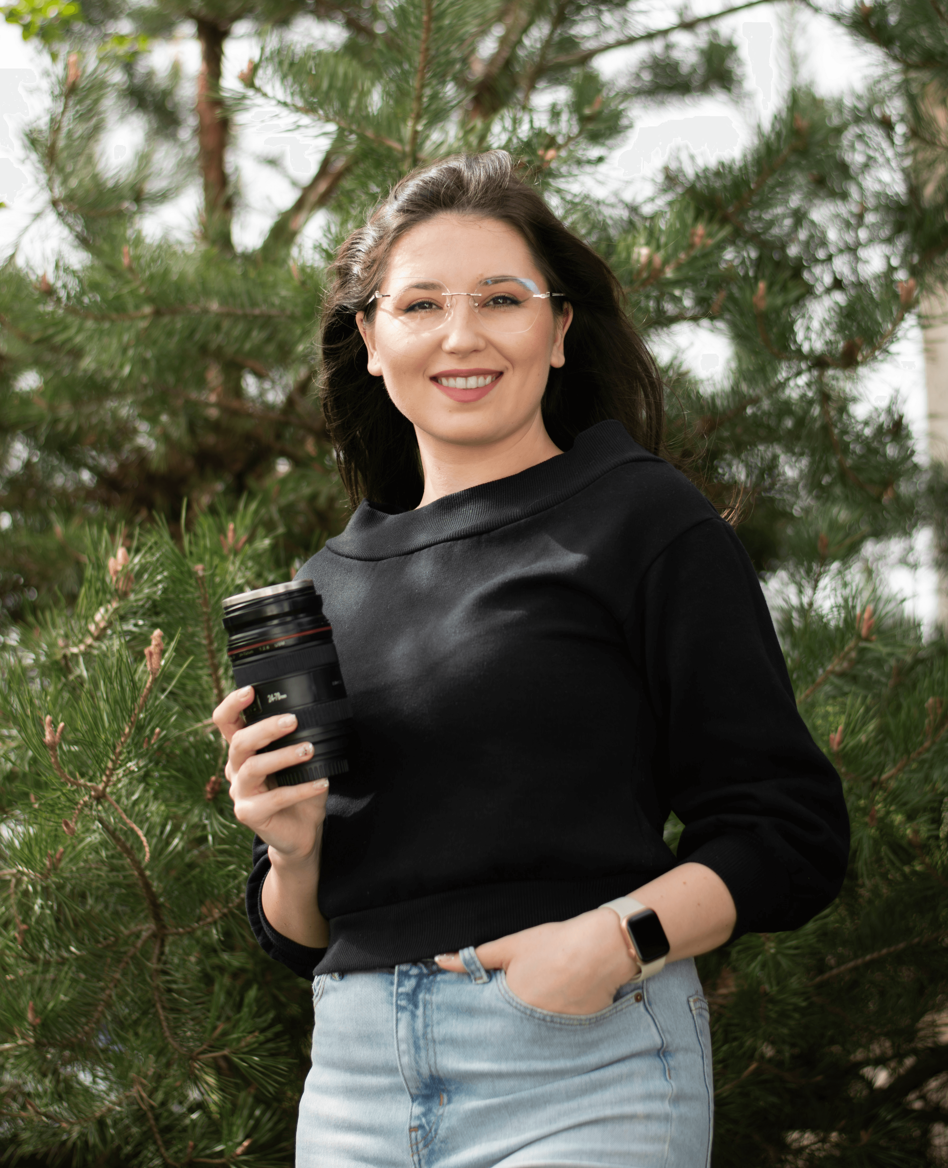 Woman in forest holding coffee cup shaped like camera lens