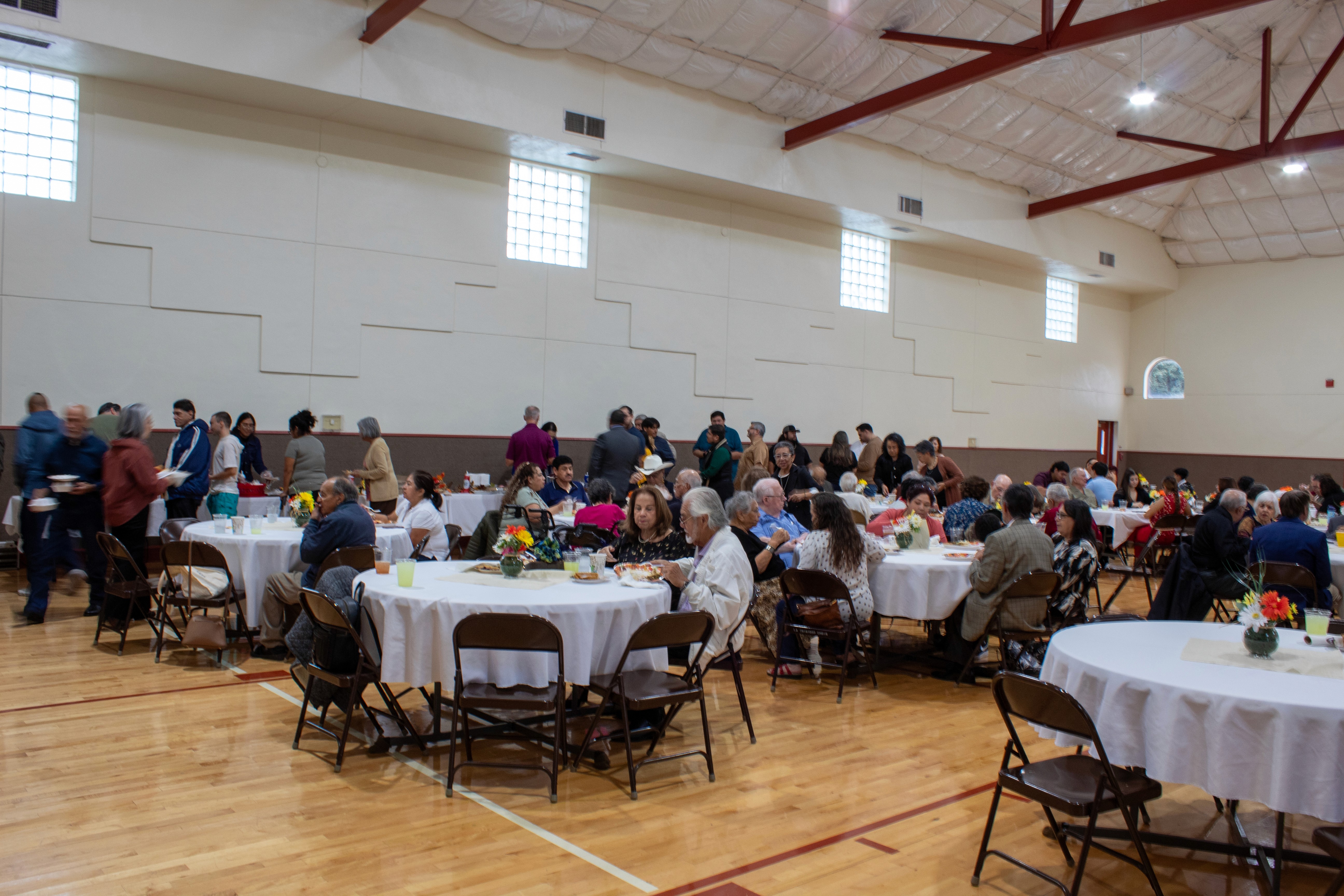 people sitting at tables in a gym