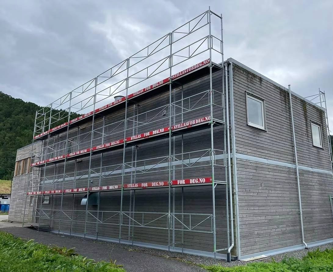 a man in a yellow shirt is working on a roof