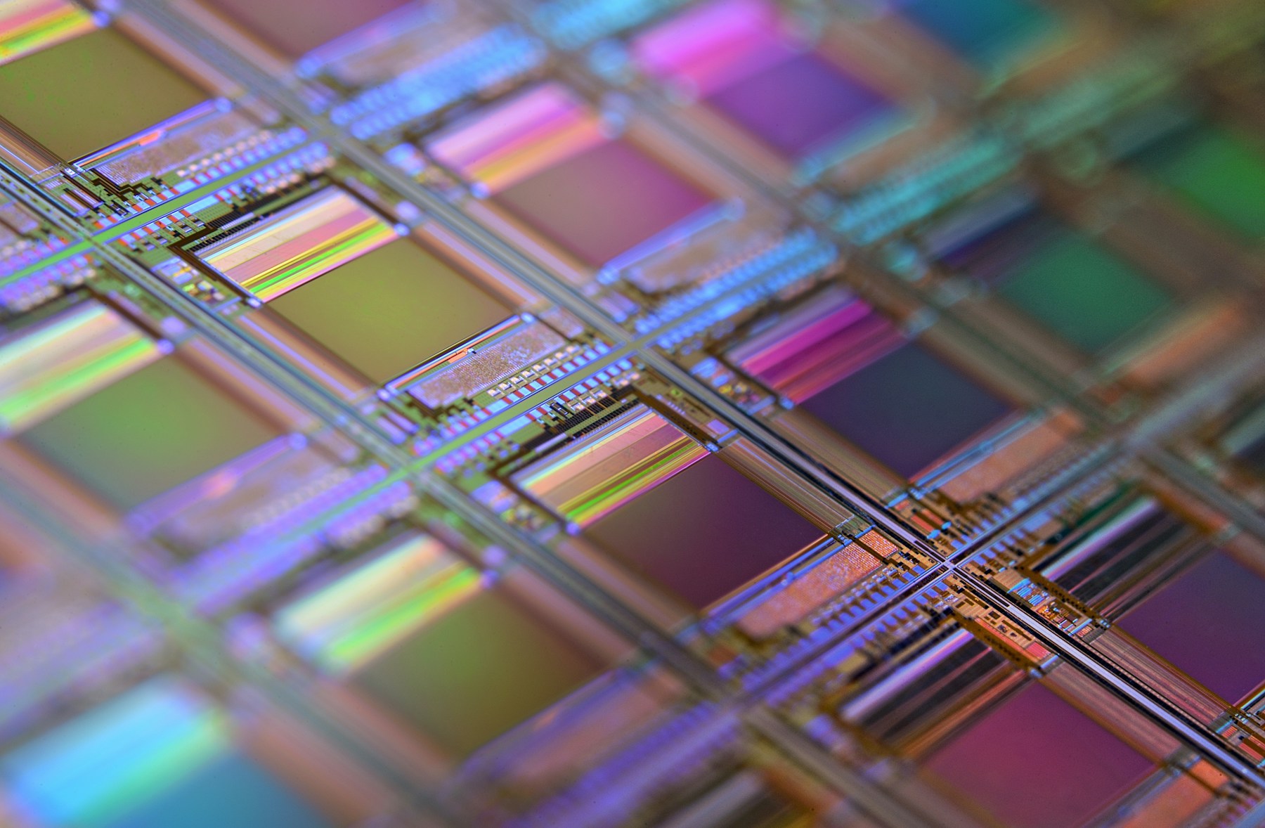 Iridescent microchip dies on a silicon wafer