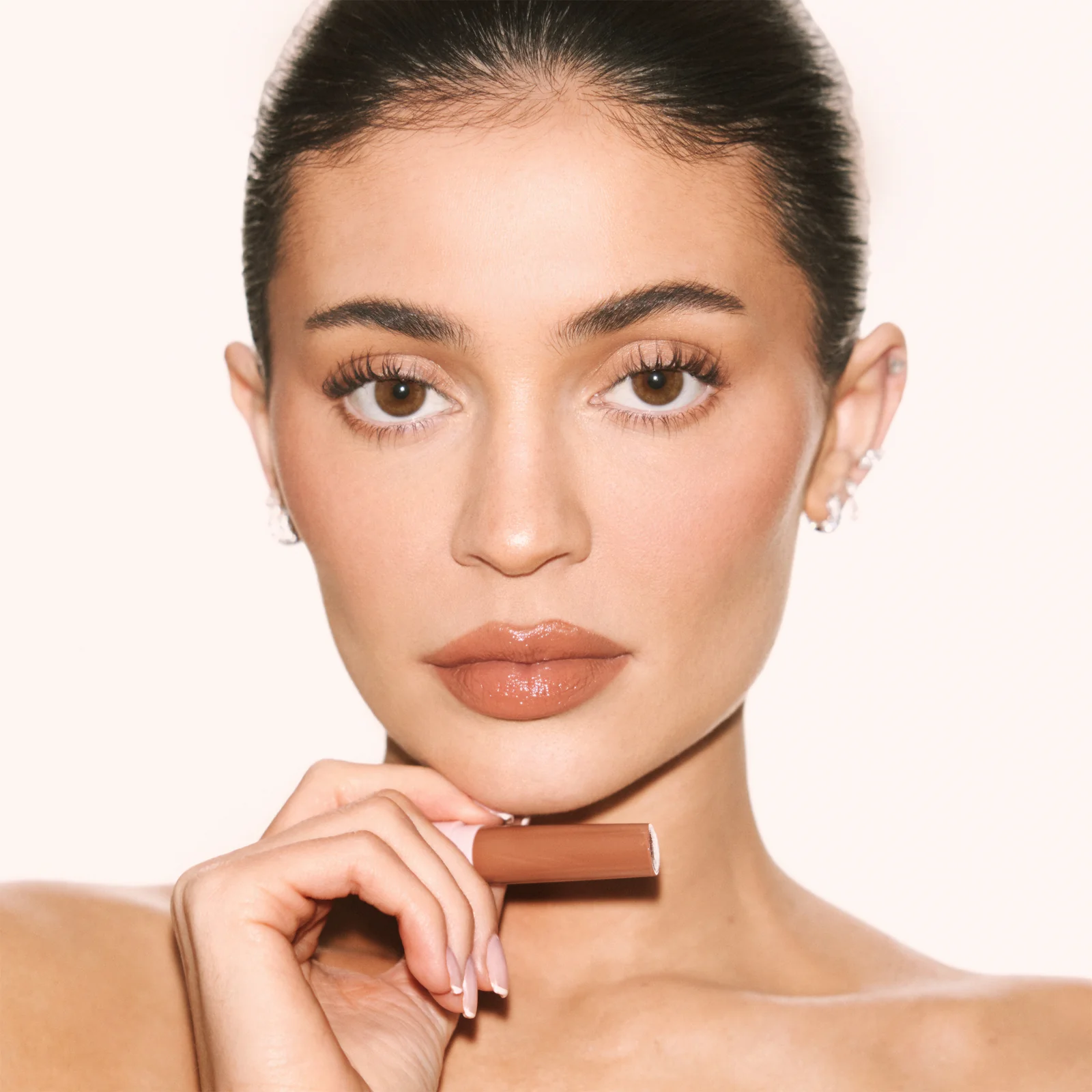 Kylie Jenner holding a Kylie Cosmetics concealer