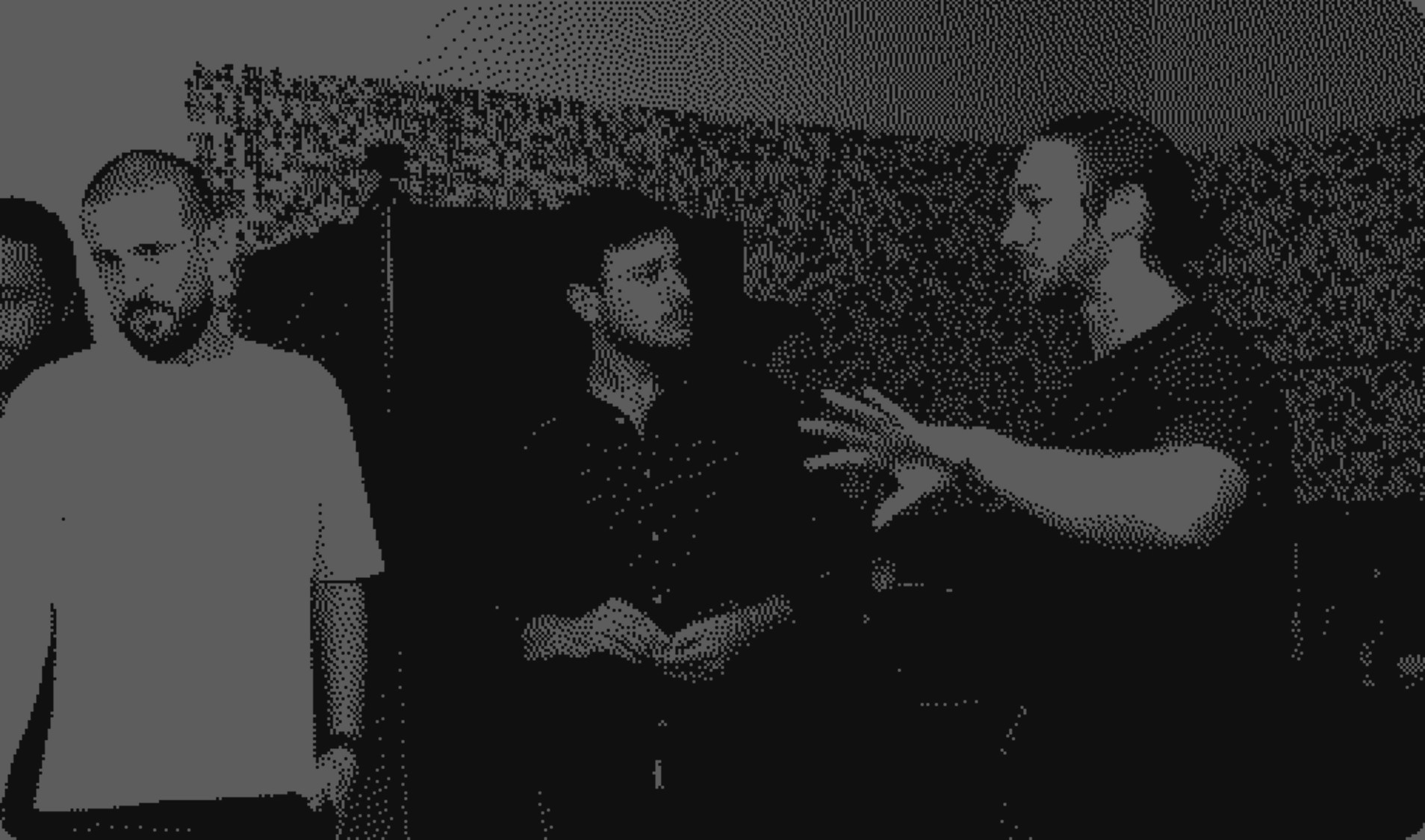 Black and white image of people working at a table with laptops, showing hands gesturing during discussion of digital content displayed on screens, with fabrica® logo in the corner.