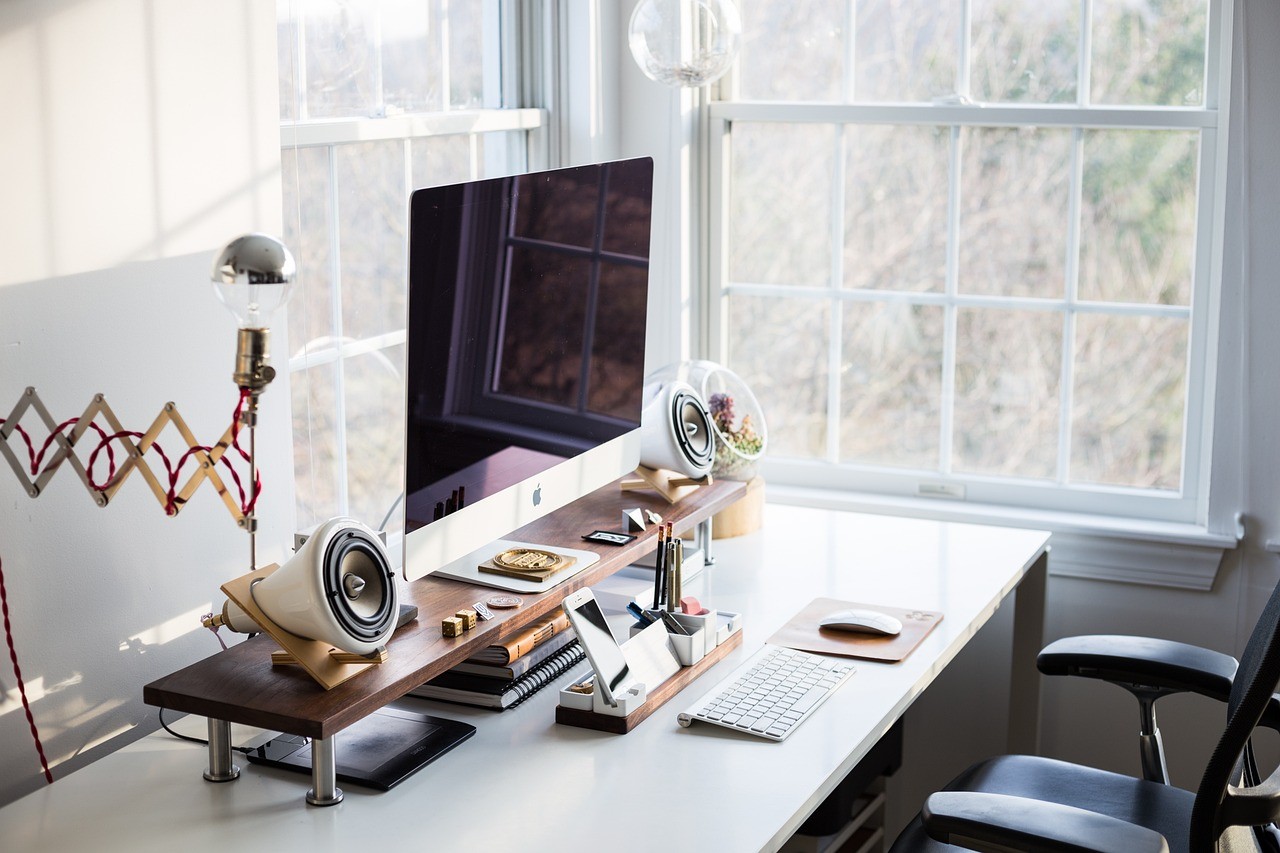 Man coding at a desk with dual monitors displaying programming code.