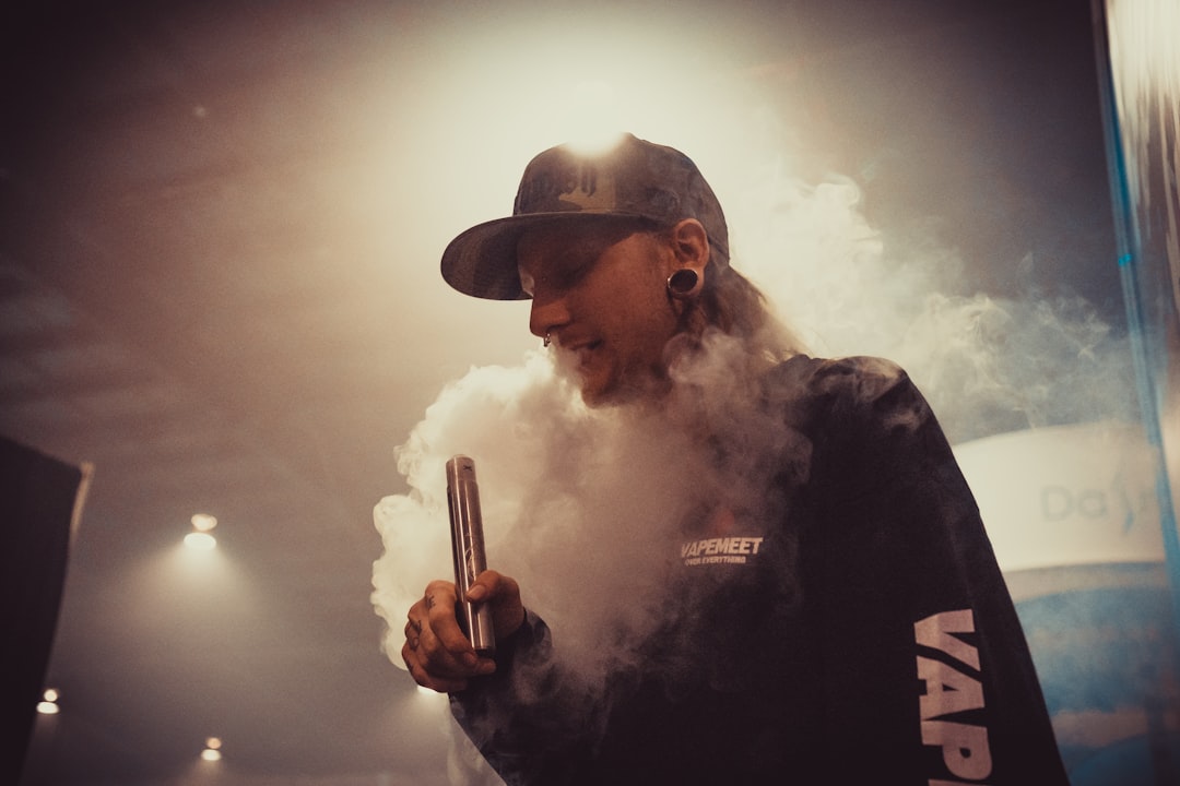 man vaping inside room with lights