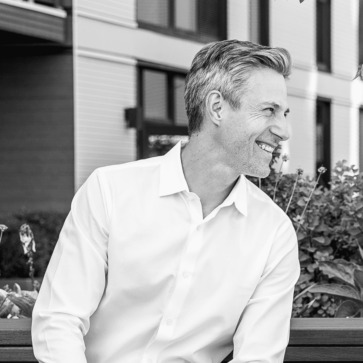 Four diverse professionals collaboratively working on a laptop, with one person pointing at the screen while others observe.