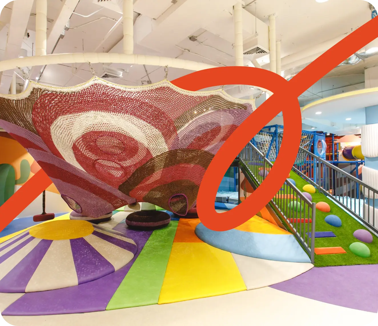 Colorful playground with green structures, a large clock, flowers, and city skyline in the background.