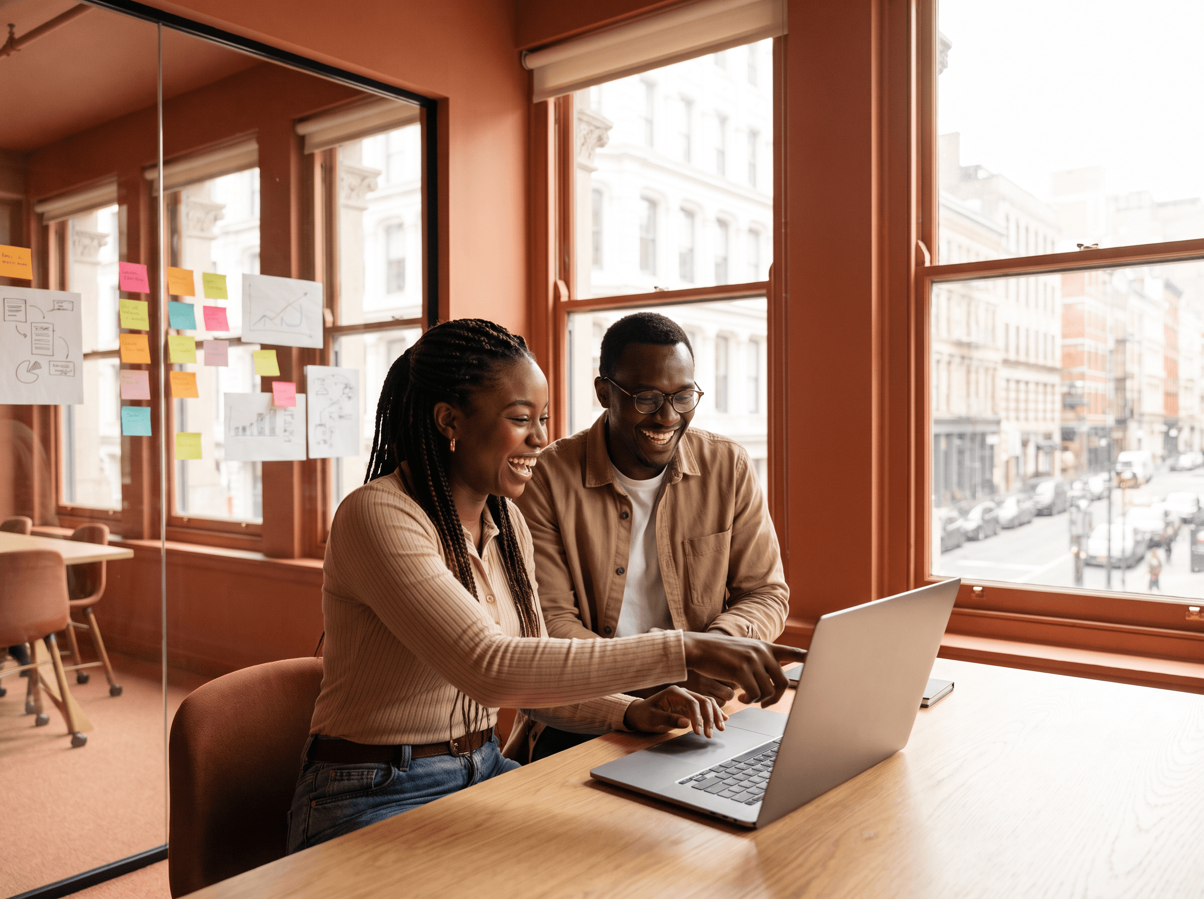Two African founders sharing an idea at a laptop