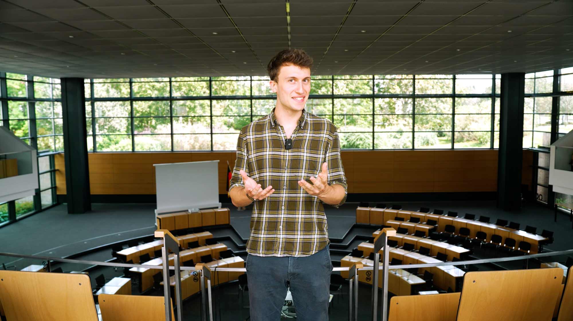Young speaker presents in a modern lecture hall, for Lohnt-Sich!-Social-Media-Campaign