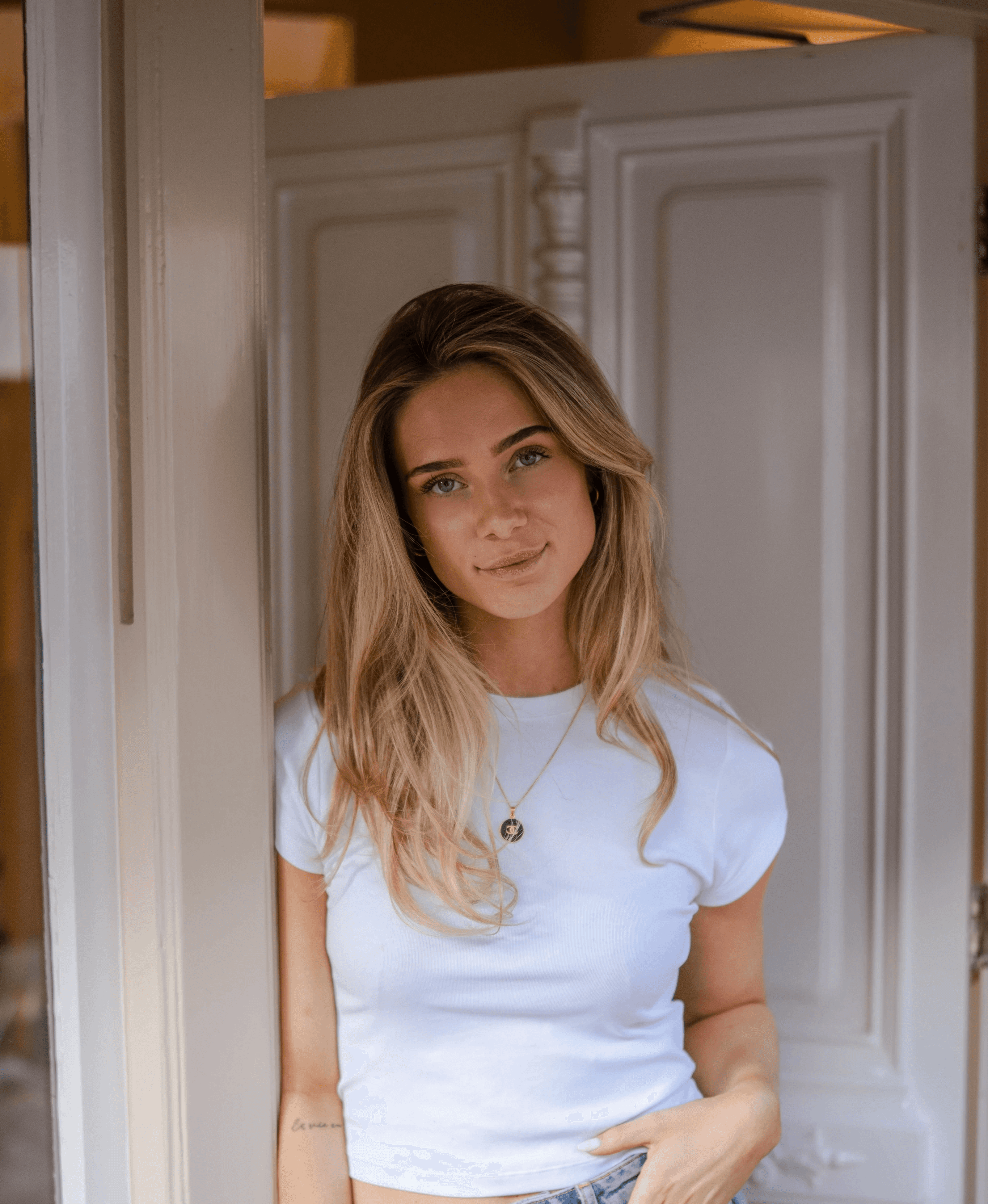 Portrait of a person in a pink sweater against a light background